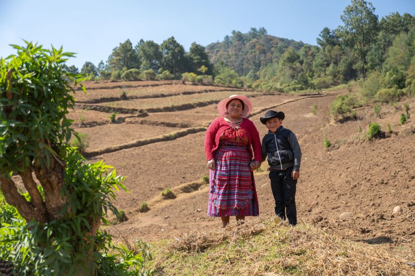 Mother and son standing in a green landscape